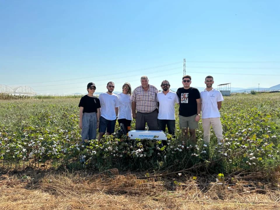 Orbiba's multidisciplinary team with farmers and an agricultural robot in a cotton field